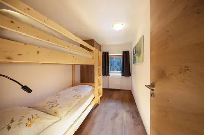 a small room with two bunk beds and a door at Gfliererhof in Fiè