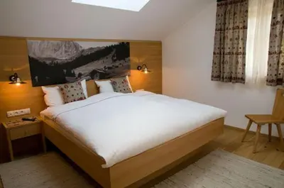 a bedroom with a large bed and a window at Wegmacherhof in Castelrotto