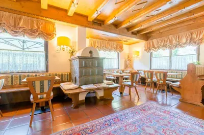 a dining room with tables and chairs and windows at Hotel Monte Civetta in Alleghe