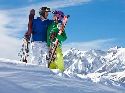 a man and a child standing in the snow with skis at Hotel Monte Civetta in Alleghe