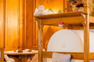 a room with a bed with a wooden wall at Hotel Monte Civetta in Alleghe