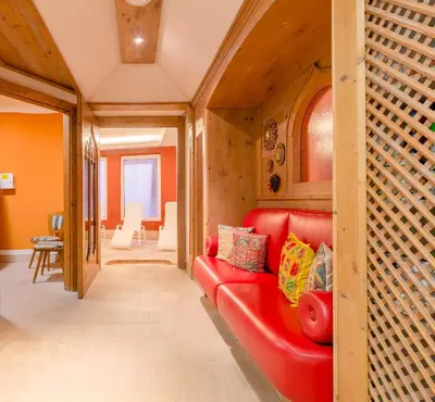 a red couch in a living room with a table at Hotel Monte Civetta in Alleghe