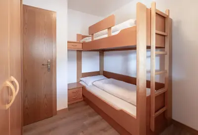 a small room with two bunk beds and a door at Petaunerhof in Schenna