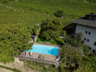 an overhead view of a swimming pool next to a house at Petaunerhof in Schenna