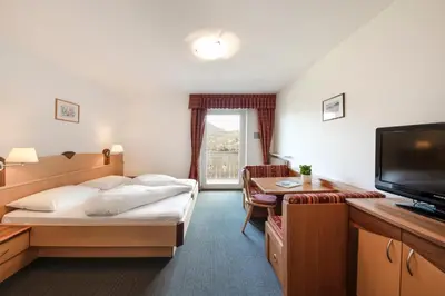 a hotel room with a bed and a flat screen tv at Petaunerhof in Schenna
