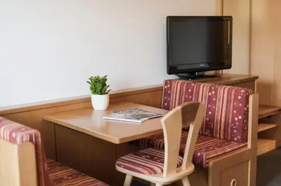 a hotel room with a table and a tv at Petaunerhof in Schenna
