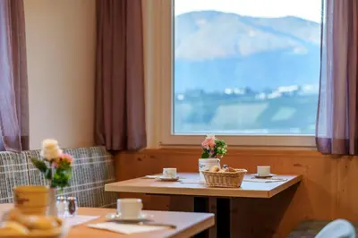 a table and chairs in a room with a window at Petaunerhof in Schenna