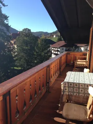 a bedroom with two beds and a chair at Saskia Residence in Ortisei