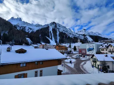 a town with snow covered buildings and a mountain at Albergo Pensione Sport in Arabba