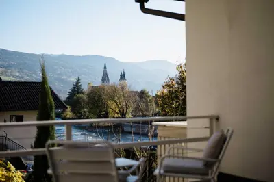 a balcony with chairs and a view of a building at Residence Isarcus in Bressanone
