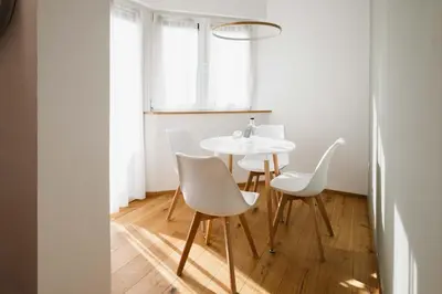 a dining room with a white table and chairs at Residence Isarcus in Bressanone