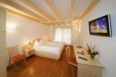 a small room with a bed and a desk with a computer at Gasthof Falger in Vollan
