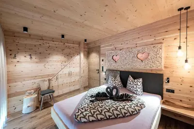 a bedroom with wooden walls and a bed in a room at Linderhof in Bressanone