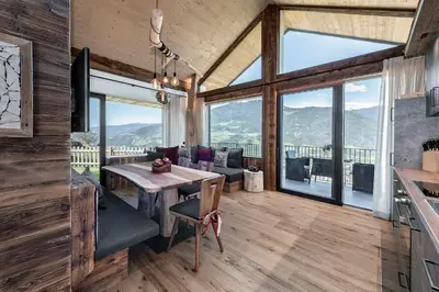 a kitchen and dining room with a table and views of mountains at Linderhof in Bressanone