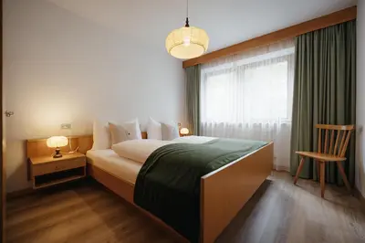 a bedroom with a bed with a window and a chair at Residence Arche Noah - Colfosco in Colfosco