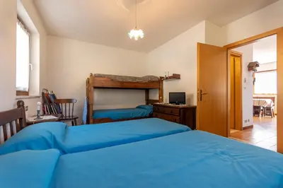 a bedroom with two blue beds and a desk at Dimora al Villaggio in Campestrin
