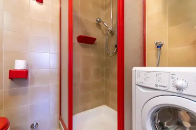a bathroom with a washing machine and a shower at Dimora al Villaggio in Campestrin