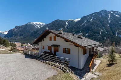 a white house with mountains in the background at Dimora al Villaggio in Campestrin