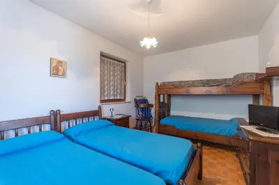 a bedroom with two bunk beds and a desk at Dimora al Villaggio in Campestrin