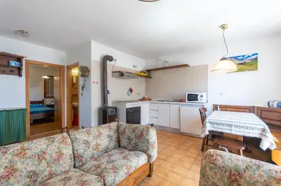 a living room with a couch and a kitchen at Dimora al Villaggio in Campestrin