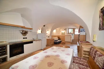 a kitchen and living room with an arched ceiling at Casa De Guidi in Meida