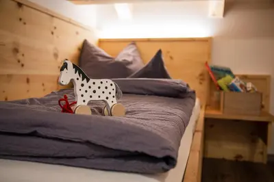 a toy horse sitting on top of a bed at Haidgerberhof - apartments & homemade food in Longomoso