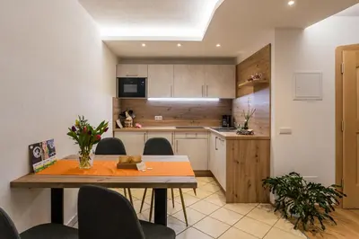 a kitchen and dining room with a table and chairs at Haidgerberhof - apartments & homemade food in Longomoso