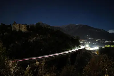 a night view of a bridge with a castle on a hill at Vermietung Obermais in Merano