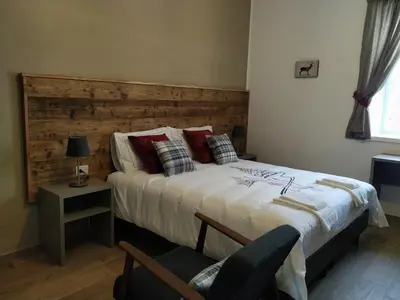 a bedroom with a large bed with a wooden headboard at Le Bifore in valle in Predazzo