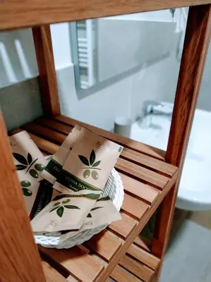 a wooden shelf with towels and a sink in a bathroom at Le Bifore in valle in Predazzo