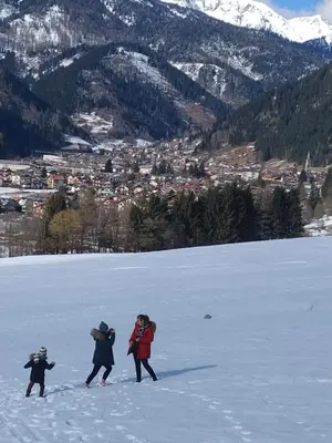 a group of people walking across a snow covered field at Le Bifore in valle in Predazzo