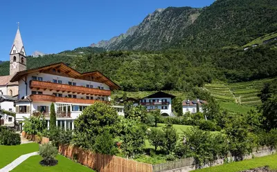 a village in the mountains with a church at Hotel Öhlerhof in Lagundo