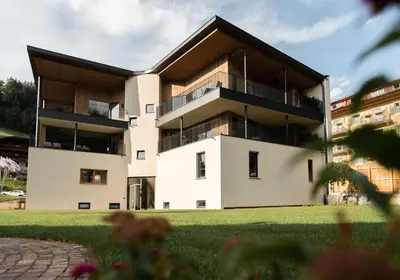 a large white building with a black roof at Chalet Insignis in Santa Cristina in Val Gardena