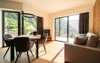 a living room with a table and chairs and a large window at Chalet Insignis in Santa Cristina in Val Gardena