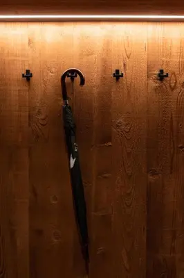 a black umbrella hanging on a wooden wall at Chalet Insignis in Santa Cristina in Val Gardena