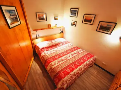 a bedroom with a bed with a red comforter at DaPolo - Cosy appartment in Val di Fassa in Campestrin