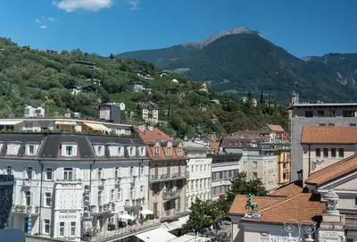 a bedroom with a bed with pillows and a window at Theatre Lodge Attico teatro in Merano