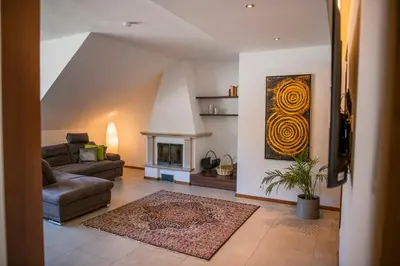 a living room with a couch and a fireplace at Theatre Lodge Attico teatro in Merano