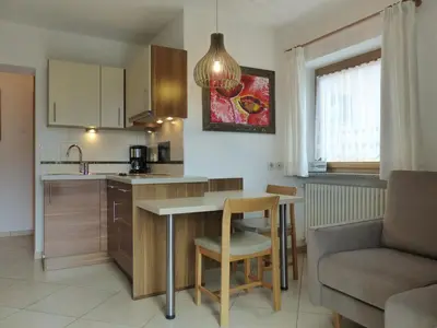 a small kitchen with a table and a couch at Ferienwohnungen Braiter in Rifiano