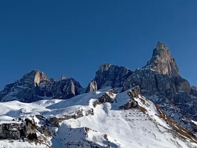 a mountain covered in snow and a blue sky at LA PULCE INNEVATA - mansarda sulle piste, Dolomiti Affitti in Passo Rolle