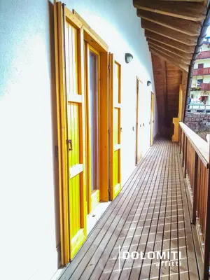 a hallway of a building with wooden doors and windows at LA PULCE INNEVATA - mansarda sulle piste, Dolomiti Affitti in Passo Rolle