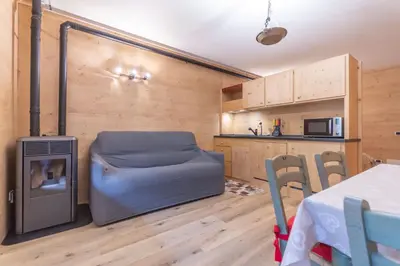a living room with a couch and a table and a kitchen at Suite Cima Pape in Rocca Pietore