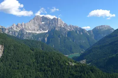 a view of a mountain range with trees and a lake at Suite Cima Pape in Rocca Pietore