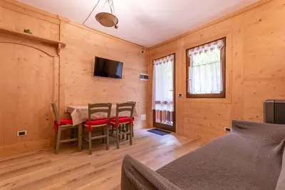 a dining room with a table and chairs and a television at Suite Cima Pape in Rocca Pietore