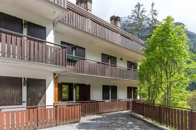 an apartment building with balconies and a tree at Suite Cima Pape in Rocca Pietore