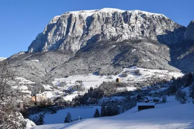 a mountain covered in snow with a village in front at App Schlossblick - Wohnung Hammerwand 2 in Umes