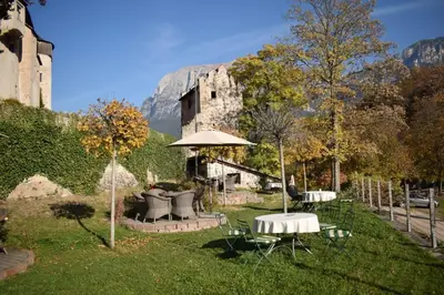 a garden with a table and an umbrella and a building at App Schlossblick - Wohnung Hammerwand 2 in Umes