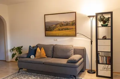a living room with a couch and a picture on the wall at App Schlossblick - Wohnung Hammerwand 2 in Umes