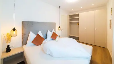 a bedroom with a white bed with pillows at Meranosuites - Garden in Merano