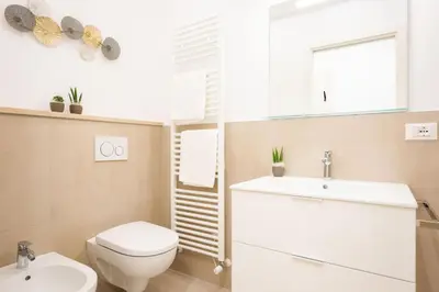 a bathroom with a white toilet and a sink at Meranosuites - Garden in Merano